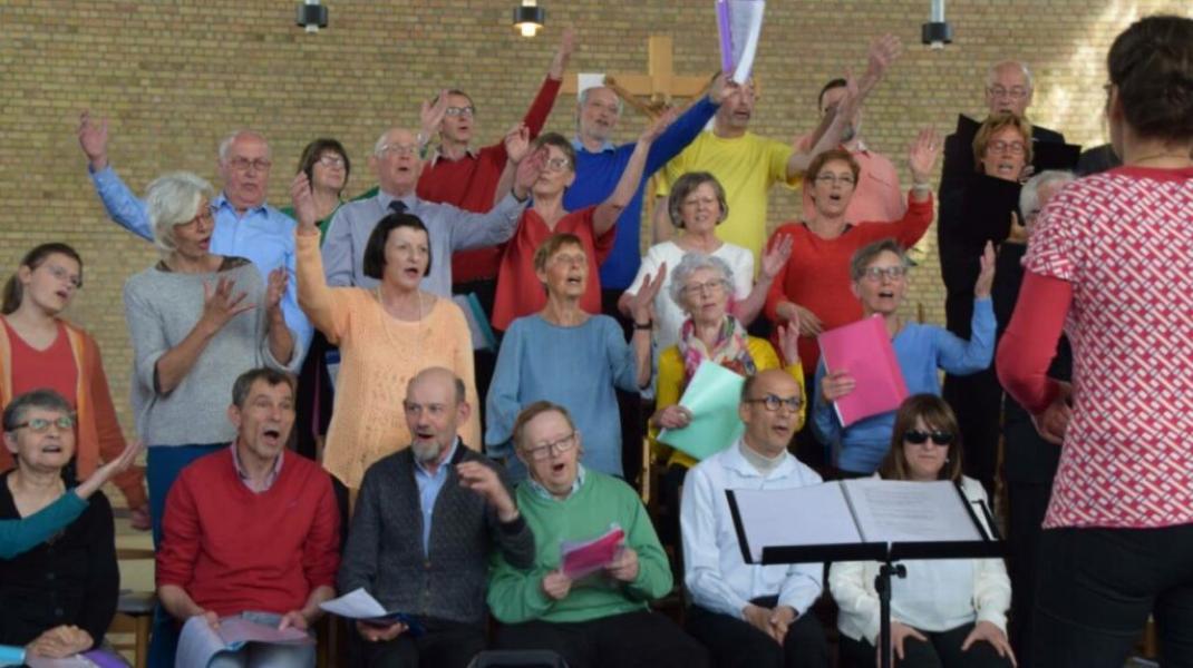 Een koor vol mensen in kleurrijke kleren die samen zingen