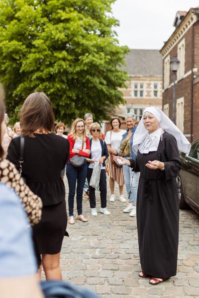 Gids verkleed als begijntje geeft uitleg