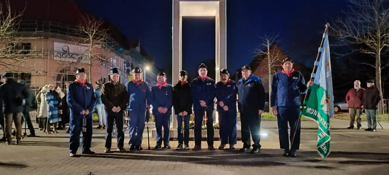 Enkele ex-mijnwerkers voor het monument van de verongelukte mijnwerkers.