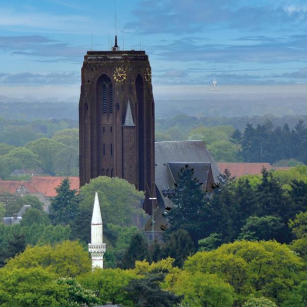 De 54 meter hoge toren van de imposante mijnkathedraal in Eisden. Op de voorgrond de minaret van de moskee.
